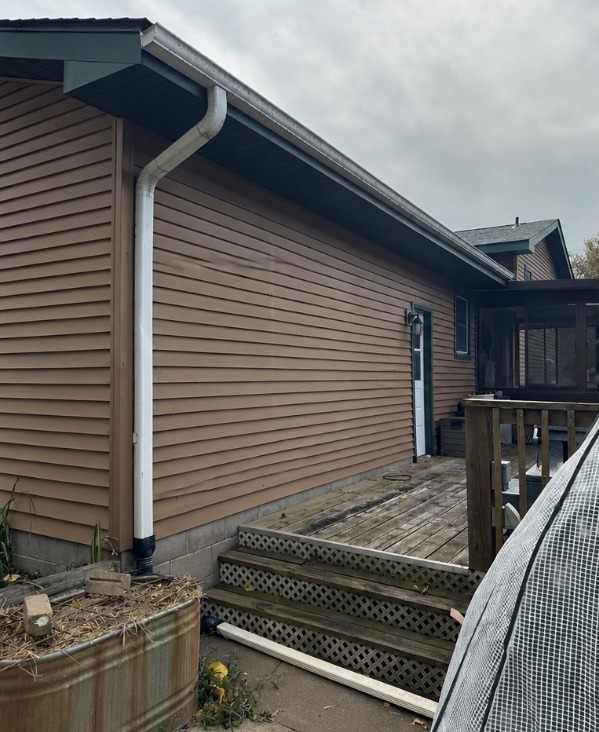 Before: an old white downspout with a detached extension lying across the walkway